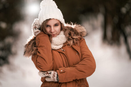 Winter Fotoshooting Mädchen mit weißer Mütze und mit brauner Jacke